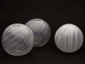 Transparent glass globes with a delicate white flowing lined pattern.
