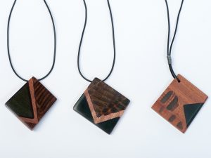 A wooden square pendant with a triangle pattern similar to an envelope icon.